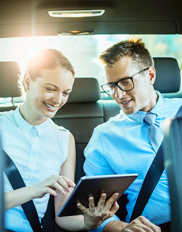 An image of happy coworkers carpooling to work. It is used with a screen from our carpool platform to explain its purpose.