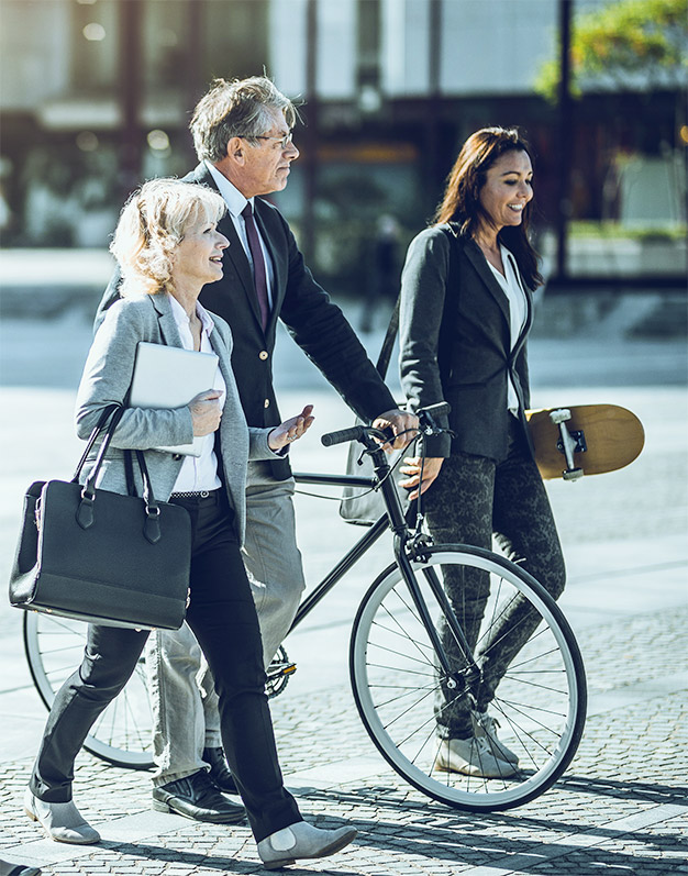 A group of coworkers using green travel options – walking and cycling scheme – to commute to work. 